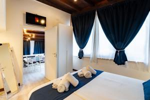 a bedroom with towels on a bed with windows at Sweet Dreams in Peschiera del Garda