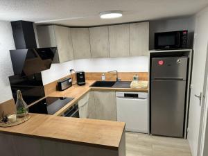 a kitchen with a stainless steel refrigerator and a sink at New Maison tout confort, bord de mer avec Parking Privé in Gruissan