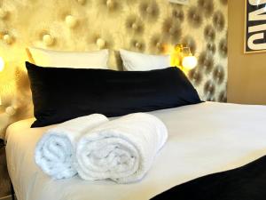 a bedroom with a bed with towels on it at Studio Alba - Confort moderne - Terrasse - Parking gratuit - Non fumeur in Fumel