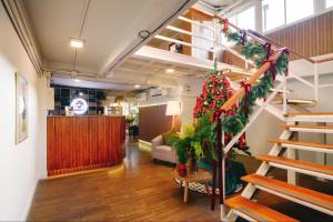 a living room with a staircase with a christmas tree at Hotel PAPA Bangkok in Bangkok