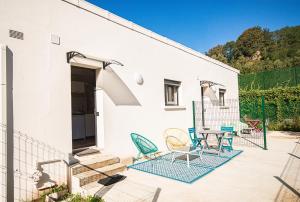 a patio with chairs and a table next to a building at Studio Alba - Confort moderne - Terrasse - Parking gratuit - Non fumeur in Fumel +40 photos