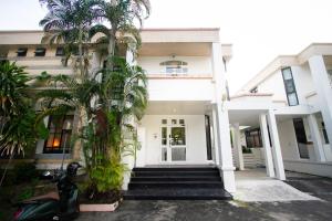 a scooter parked in front of a building with palm trees at Spacious 4-Bedroom Oasis in the Heart of Sukhumvit in Bangkok