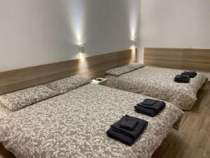 two beds in a room with black towels on them at Dimora Vaticano apartments in Rome