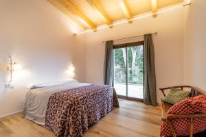 a bedroom with a bed and a window at Casa Gessamí Alojamiento en el Pla de l'Estany in Camós
