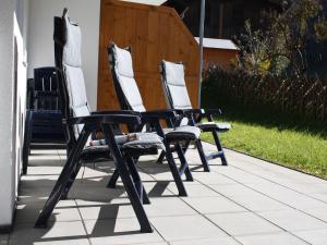 trzy białe krzesła siedzące na patio w obiekcie Apartment in Kaprun near ski lift w Kaprunie