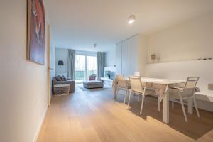 a dining room and living room with a table and chairs at Duinhof VI 6 in Cadzand