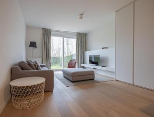 a living room with a couch and a table at Duinhof VI 6 in Cadzand