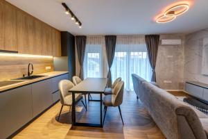 a kitchen and dining room with a table and chairs at V APARTMENT 2 Futog in Futog