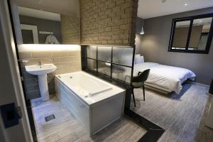 晋州市Hotel Kkuljam Stay的带浴缸、水槽和床的浴室