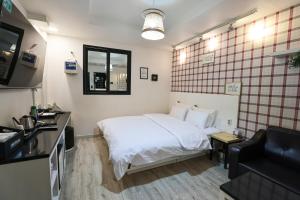 晋州市Hotel Kkuljam Stay的配有床和电视的酒店房间