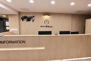 晋州市Hotel Kkuljam Stay的带有接收台的办公室,上面有读移民的标志