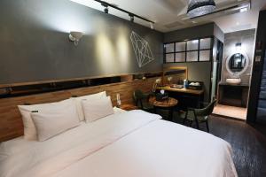 晋州市Hotel Kkuljam Stay的卧室里有一张白色的大床和一张书桌