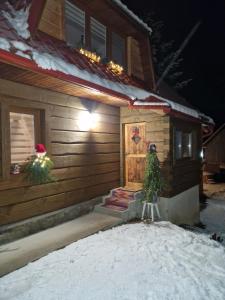 a house with a christmas tree in front of it at Chalupa nad sadom in Liptovská Kokava