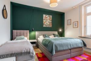 a bedroom with two beds and a green wall at 94 Relax Homedesign Ferienwohnung in Elmshorn bei Hamburg in Elmshorn