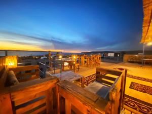 een dakterras met tafels en stoelen in de nacht bij 33 Taghazout in Taghazout