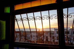 een uitzicht op een zonsondergang door een raam bij 33 Taghazout in Taghazout