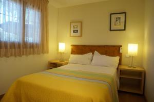 a bedroom with a bed with two lamps on tables at Casa la Paloma in Es Caló