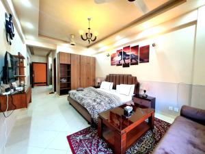 a bedroom with a bed and a table and a couch at The Signature Studio's in Rawalpindi