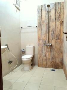 a bathroom with a toilet and a wooden door at The Signature Studio's in Rawalpindi +9 photos