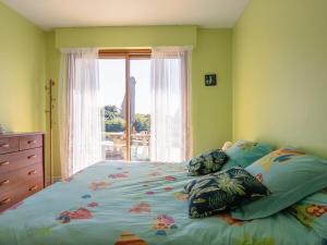 een slaapkamer met een groot bed en een raam bij La Maison de Saint-Hernot in Crozon