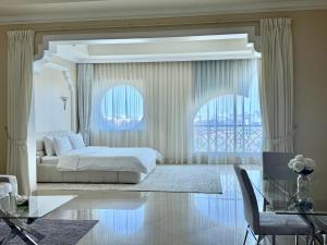a bedroom with a bed and a table and a window at Private Suites Al Hamra Palace at golf & sea resort in Ras al Khaimah +54 photos