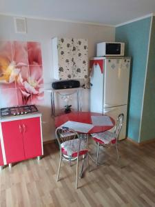 a kitchen with a table and chairs and a refrigerator at Центр Апартаменти готель ГРАН in Poltava