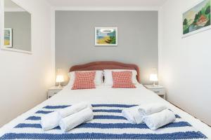 a bedroom with a large white bed with four pillows at C22 Beachfront Villa - SPA BATH, POOL, PRIVATE BEACH, PARKING FREE in Marina dʼAndora