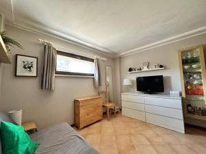 - une chambre avec un lit, une télévision et une commode dans l'établissement Brevi periodi Reggio Emilia, à Reggio d'Émilie