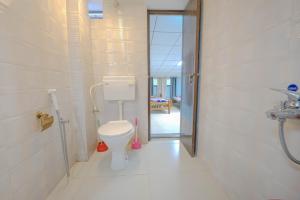 a bathroom with a toilet in a room at UDUPI HOMESTAY- White House in Udupi +53 photos