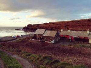 a group of buildings on a beach next to the ocean at Seaside Cottage in HAW +14 photos