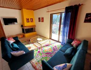 a living room with two blue couches and a tv at Casa de PavL-1 in Pavliani
