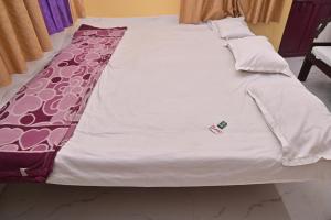 un letto con una coperta bianca e una bottiglia sopra di Luv Kush Homestay ayodhya a Ayodhya