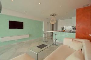 a living room with a couch and a kitchen at Malibu Beach Deluxe Wohnung Strandlage in Benalmádena