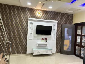 a living room with a flat screen tv on a wall at Happy home stay in Kanāria