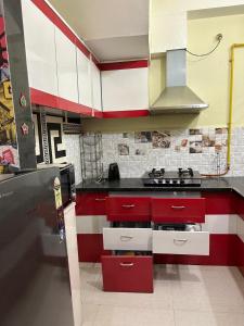 a kitchen with red and white cabinets and a stove at Happy home stay in Kanāria