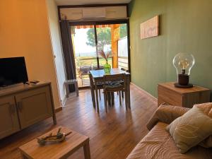 ein Wohnzimmer mit einer Couch und einem Tisch mit einer Lampe in der Unterkunft Appartement n 79 Moriani plage in Santa-Lucia-di-Moriani