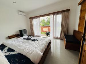 AirsatangMedewi Hady Surf Camp的一间卧室，配有一张大床和一扇大窗户。 更多18张照片