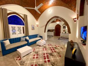 a living room with a blue couch and a table at ELamir house in Al Aqālitah