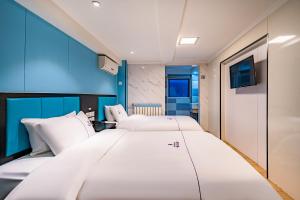 北京Dequan Hotel chaoyang high speedtrain of China Branch的一间蓝色墙壁的房间里有两张床