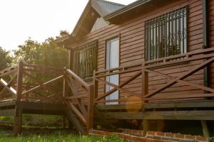 a home with a wooden deck and railings at Cabaña Lanèr in San Vicente