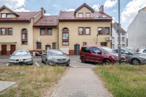 a group of cars parked in a parking lot in front of a building at Apartament Mąki Gram in Złocieniec +7 photos