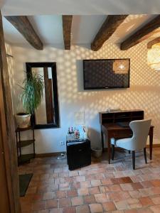 a living room with a piano and a desk at Hotel L'Aunette Cottage in Chamant