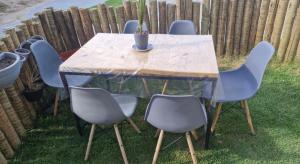 a wooden table with four chairs and a potted plant on it at Vog caruaru in Caruaru