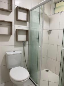 a bathroom with a toilet and a glass shower at Vog caruaru in Caruaru +4 photos