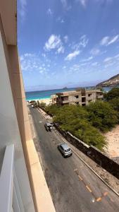 a car driving down a road next to the beach at Duarte Apartments - Império in Mindelo
