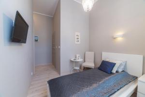 małą sypialnię z łóżkiem i telewizorem w obiekcie Due Passi Apartamenty w Sopocie w mieście Sopot