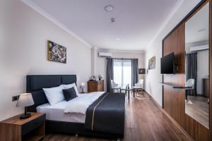 a bedroom with a bed and a table and chairs at sh hotel business in Karşıyaka