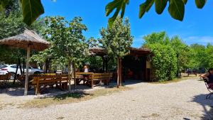 a restaurant with benches and umbrellas in a park at Marina Park in Vama Veche
