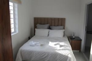 a bed with two towels sitting on top of it at one bedroom apartment A1 in Cape Town