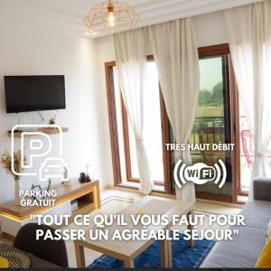 ein Wohnzimmer mit einer Couch und einem Fenster in der Unterkunft Cosy cocon au coeur de Gueliz-Parking gratuit in Marrakesch